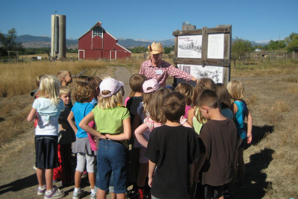 Kids on a tour of Agricultural Heritage Center with a barn in the background