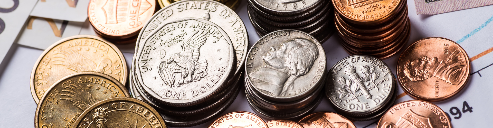 Stacks of different denomination United States coins on top of papers