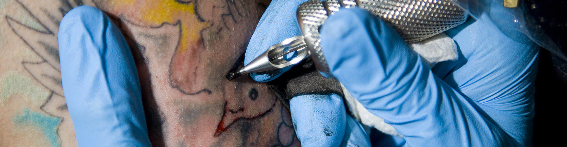 tattoo artist using gloves
