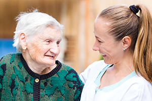 adult woman and elderly woman smiling at each other