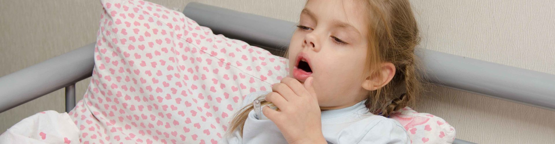 little girl coughing in bed