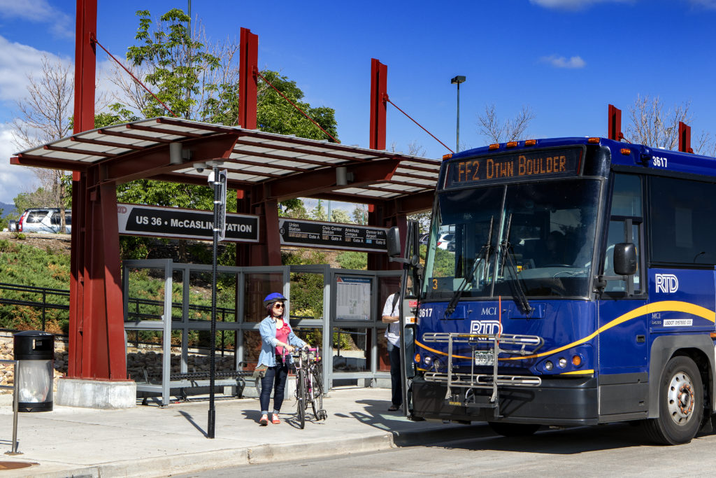 Bike rider preparting to load her bike onto an RTD bus at a bus station