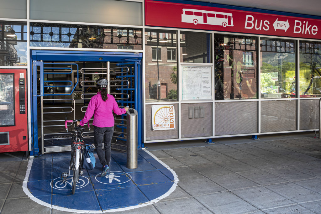 Bike rider walking into a Bike-n-Ride shelter