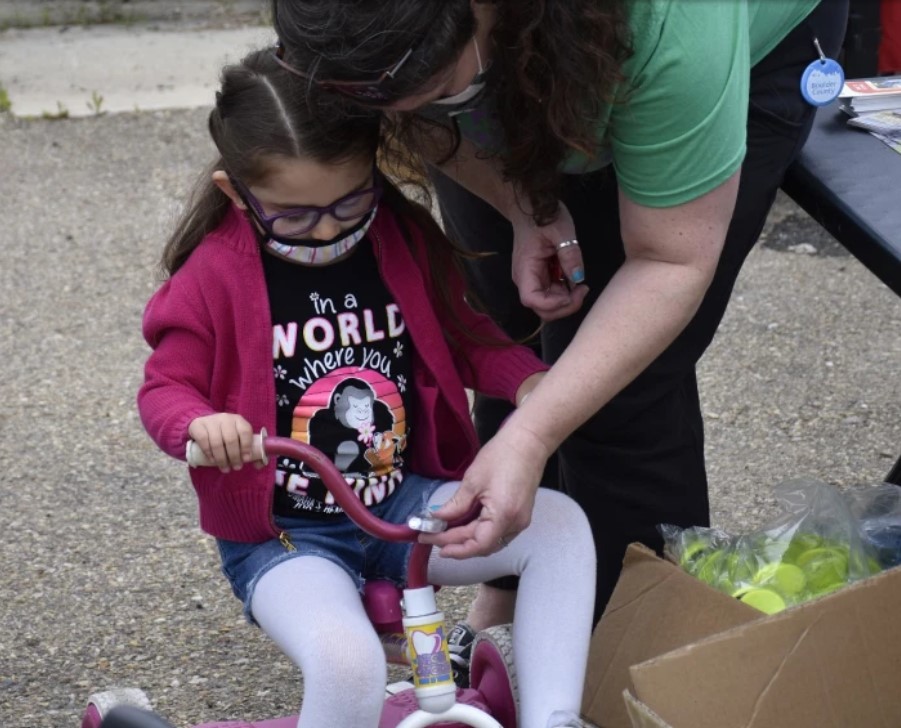 Cammie Edson (Boulder County) helps 4-year-old attach lights to her new bike
