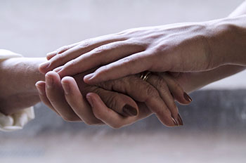 Young man hands holding old senior woman hand.Close up