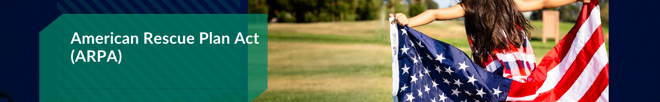 A girl stands in the grass, proudly holding an American flag, symbolizing patriotism and freedom.