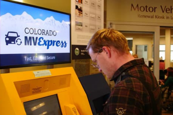 Man using the motor vehicle express kiosk to renew his vehicle registration