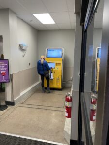 Woman using the motor vehicle self-service kiosk inside the Louisville King Soopers