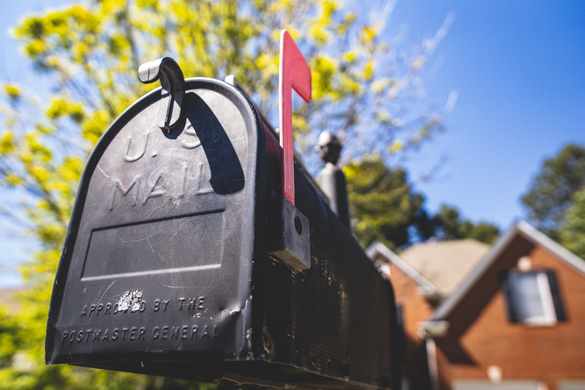 Mailbox in front of a house with red flag up
