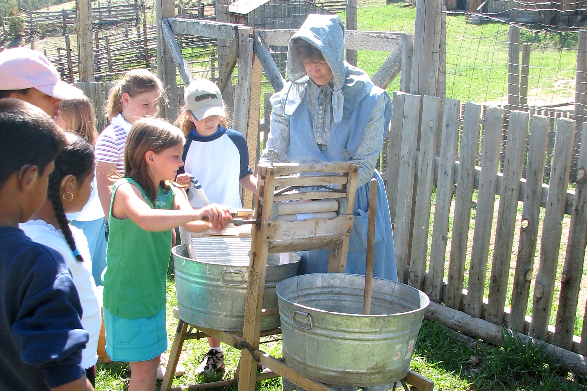 A group of children perform laundry using old-fashioned tools