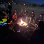 Teens gathered around a campfire