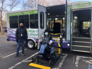 Ride Free Lafayette Bus showing a person in wheelchair boarding or deboarding and the bus driver standing by to help.