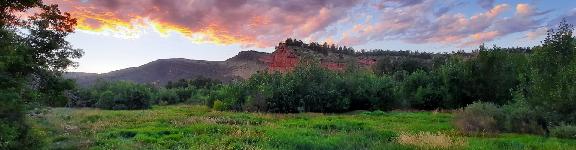 Landscape scene with low mountain and sunset with clouds