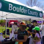 Community members visit a Boulder County team at an outdoor event.