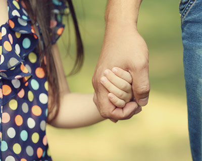 Daughter holding her mother's hand while walking