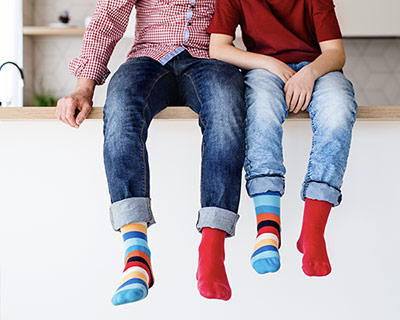 Kids with colorful socks dangling their legs from the kitchen counter