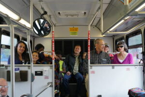 A group of people of all ages riding the bus together.