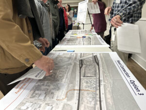 Bikeway Project 119 meeting with participants reviewing detailed plans on a table.