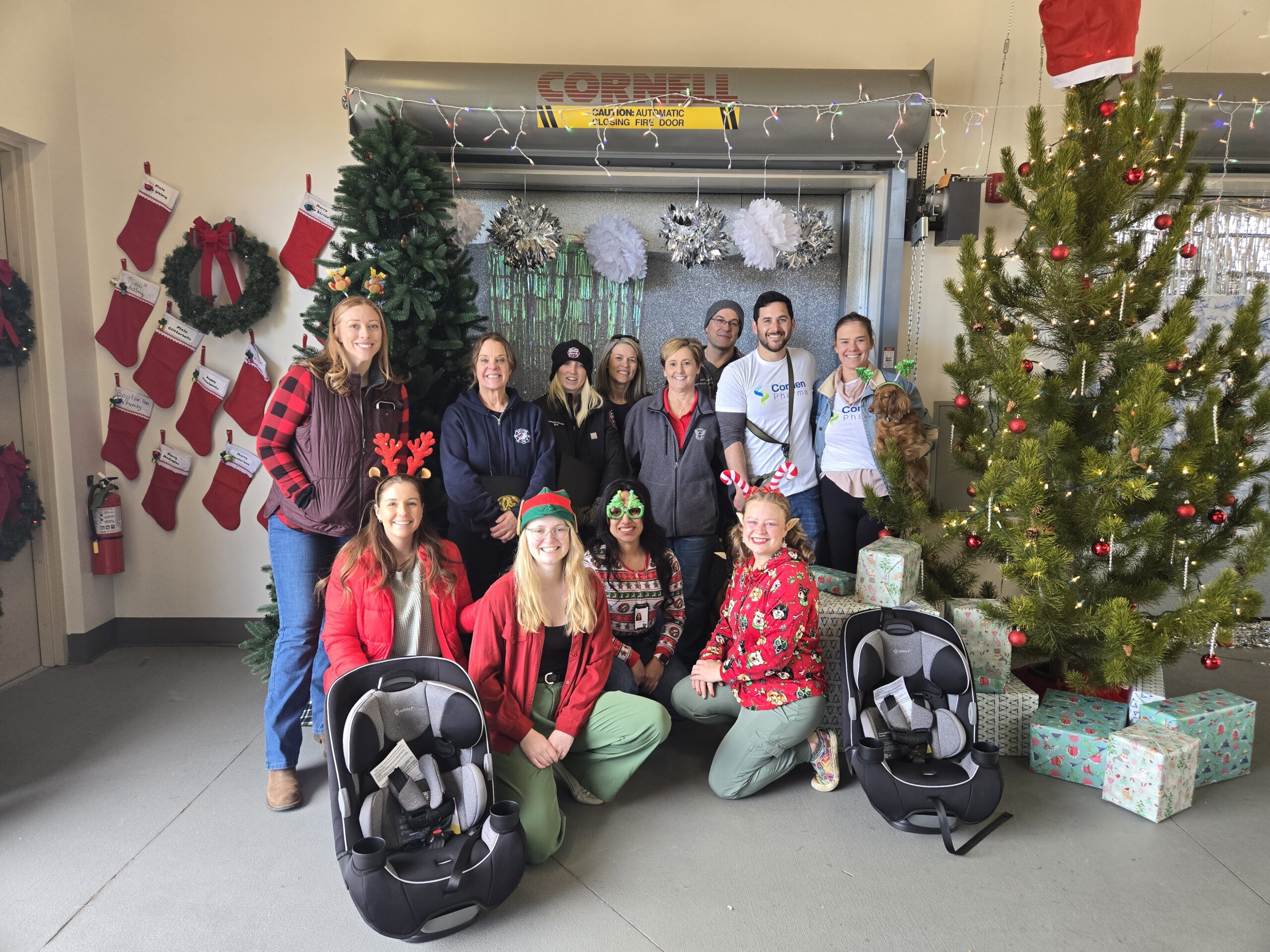 Group of people posing for a photo amidst holiday decorations.