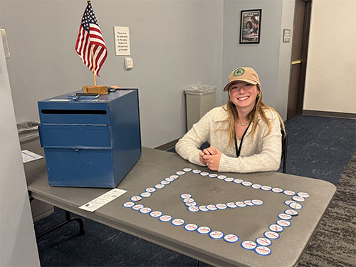 A student election judge works at a Vote Center