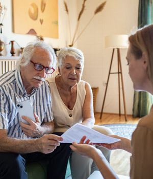 Young woman assisting older adults with paperwork