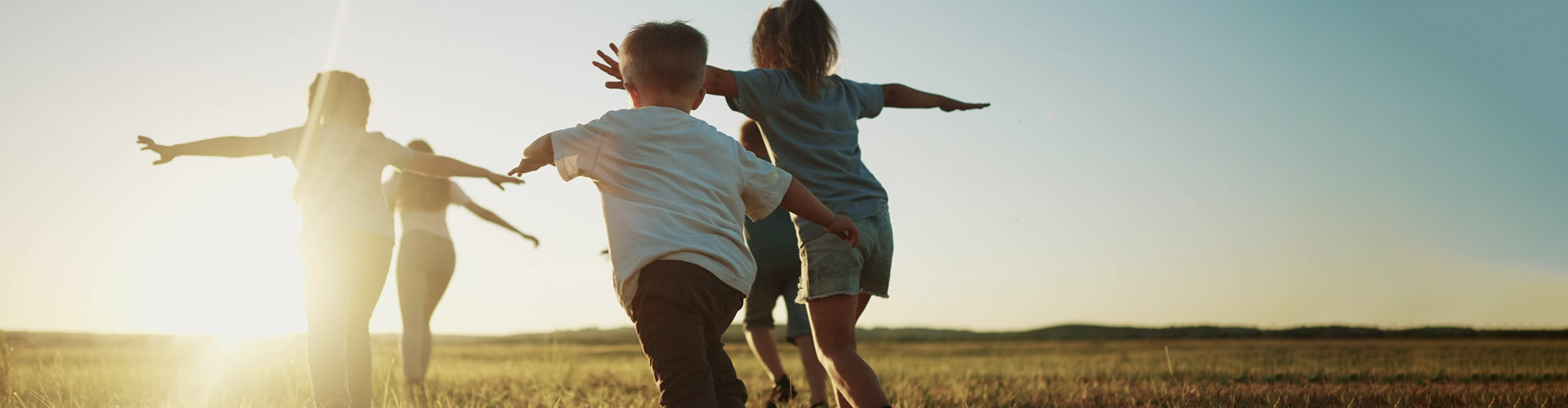 Group of children joyfully running with their arms raised high