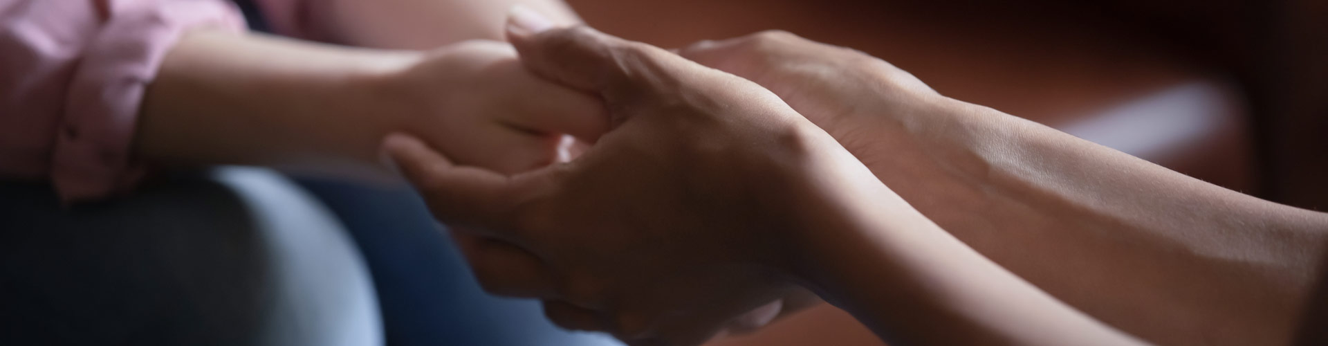 Two people holding hands in support.