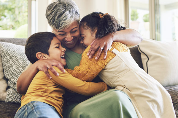 A warm family moment with two children hugging their grandma.
