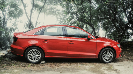 a red car parked in front of trees