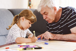 Grandfather and granddaughter drawing together