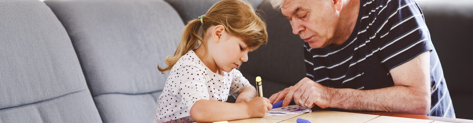 Grandfather and granddaughter drawing together