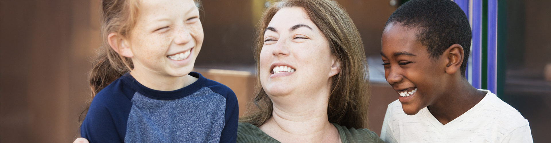 A mother and her two children smiling happily.