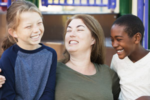 A mother and her two children smiling happily.