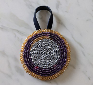Beadwork using orange, purple, and white beads