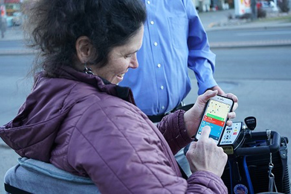 Adult receiving assistance from a Mobility for All Ambassador who is helping her navigate mobile options.