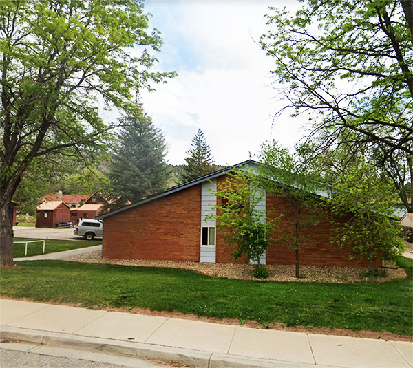 Exterior building view of a home at Bloomfield Place in Lyons. It's a one story brick home with a vaulted roof.