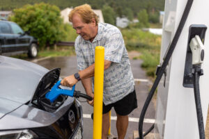 Person charging electric car at an EV station