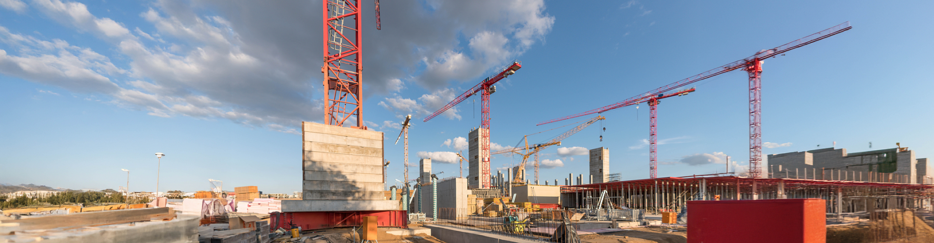 A construction site with cranes and a central elevator tower. Represents capital projects.