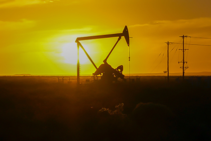 Oil and gas development against sunset background.