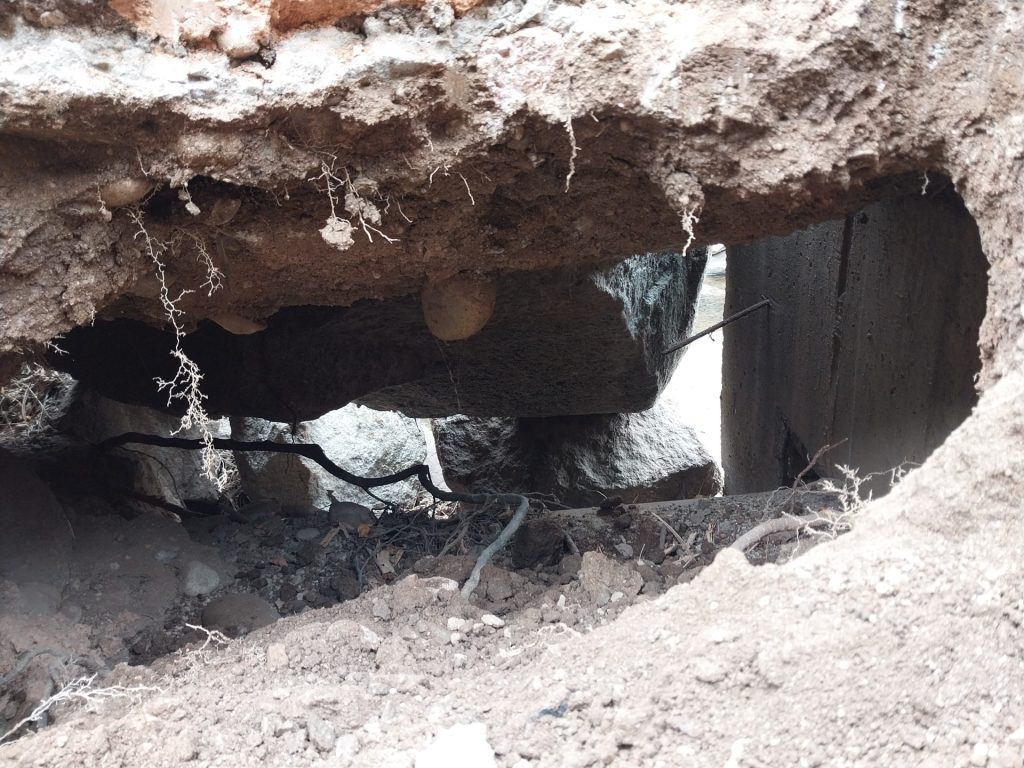 A large hole that sits below the trail.