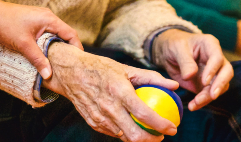 close-up of elderly man's hand holding an exercise ball