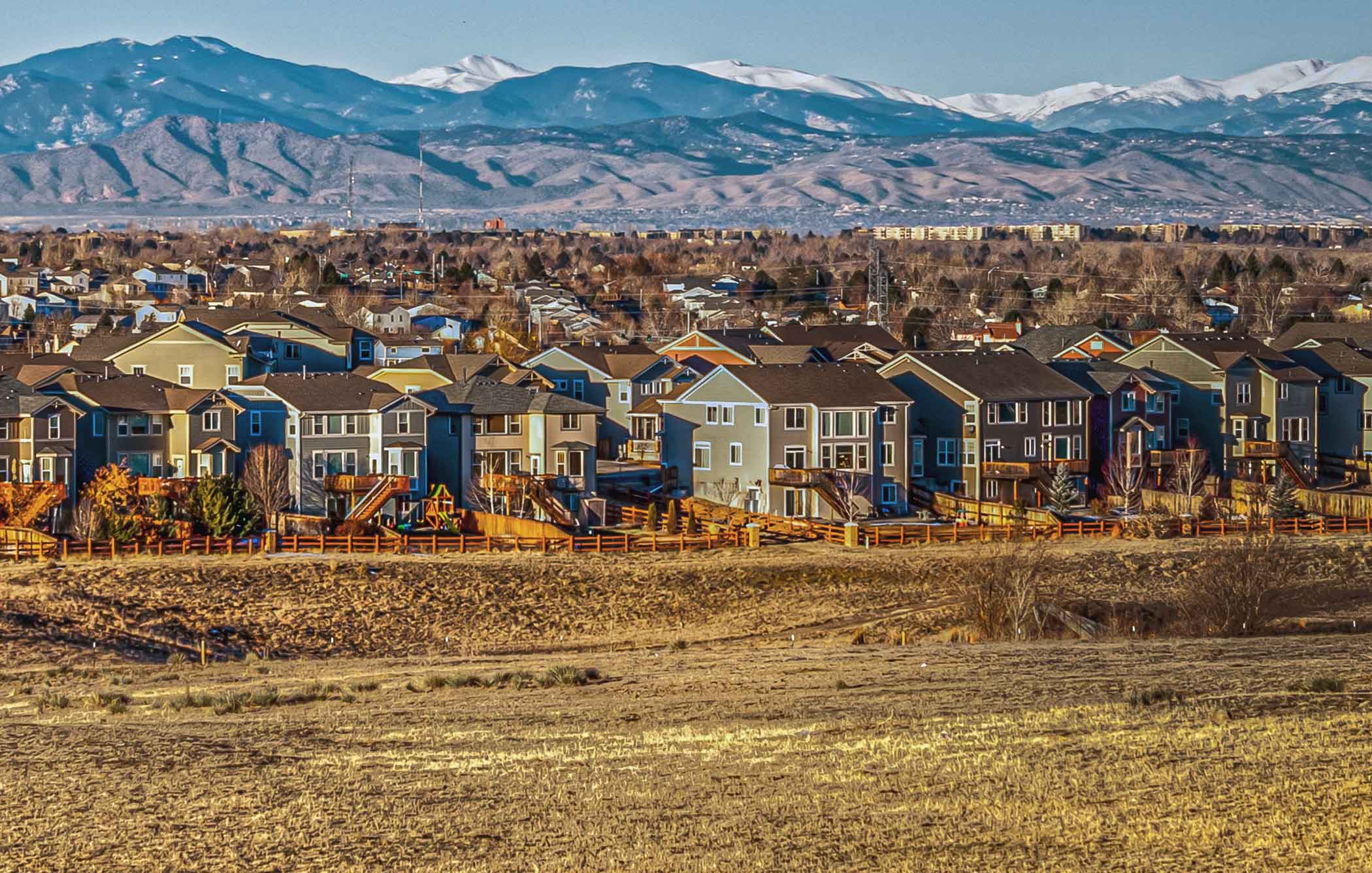 Rows of houses that back up to open space with the foothills and mountains in the background.