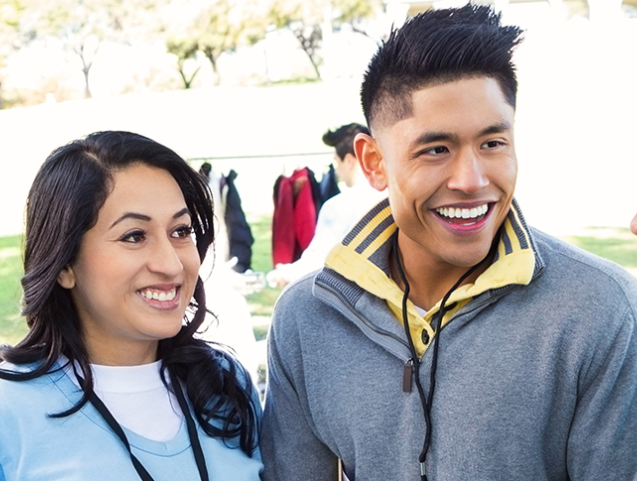 man and woman looking at friend and smiling