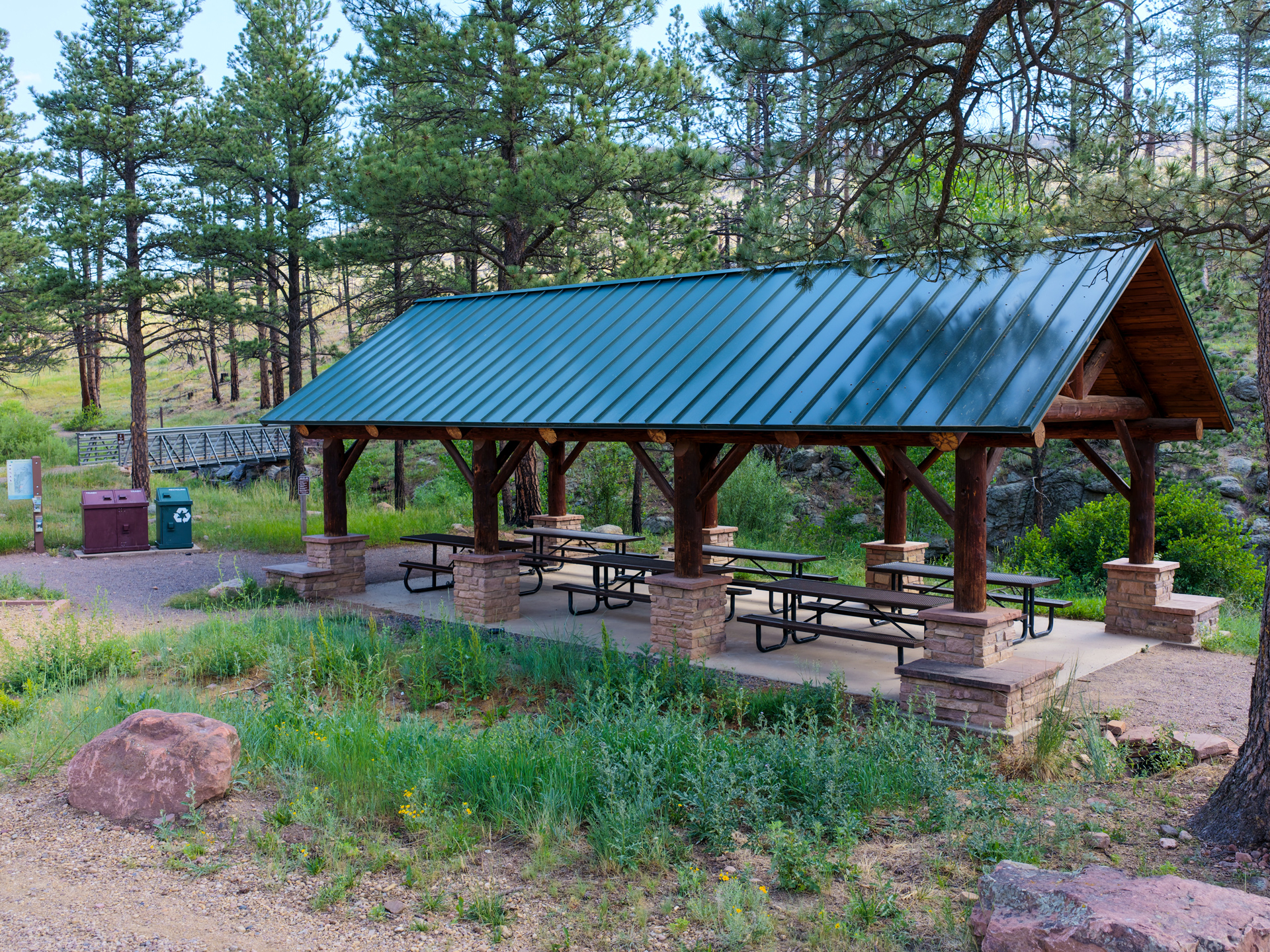 Shelter at Heil Valley Ranch with six picnic tables surrounded by pine trees.