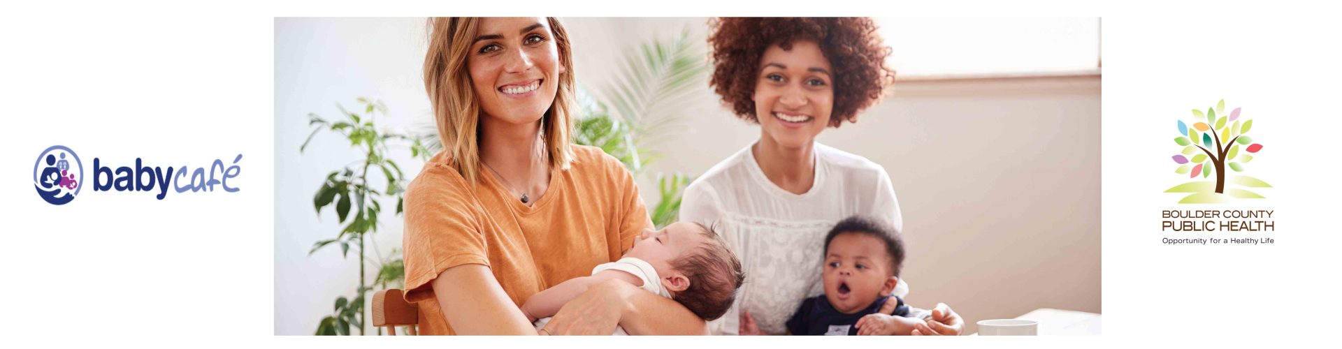 two women sit together holding their infants